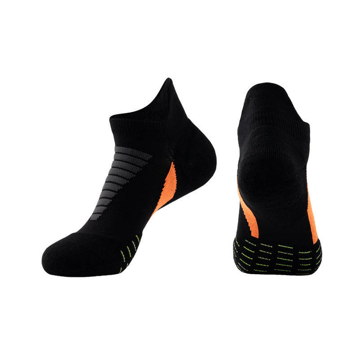 Black ankle socks with gray stripes and orange highlights displayed against a black background.