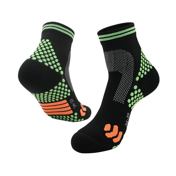 Black athletic ankle socks with neon green grip dots, orange arch support, and green elastic cuffs.