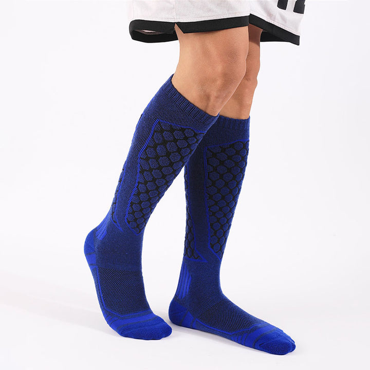 Person wearing blue thick padded merino wool over-the-calf skiing socks for warmth and support.