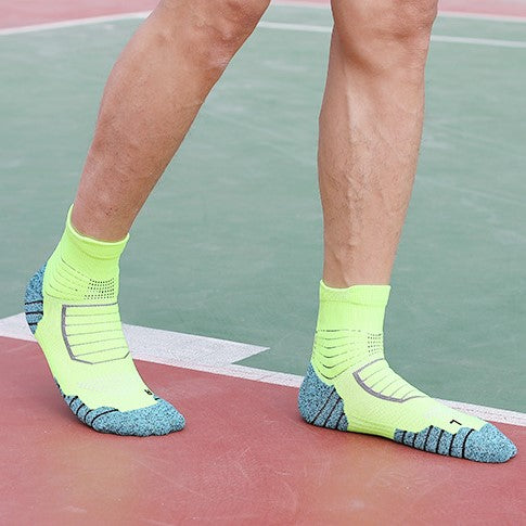 Wearing bright yellow and blue color-blocked cushioned golf socks, ideal for sports surfaces.