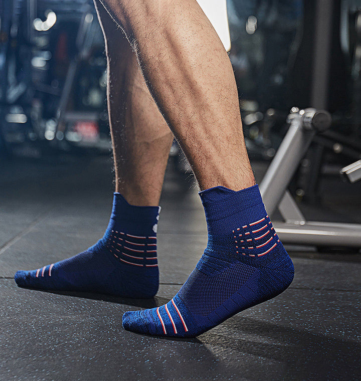 A person wearing blue socks with red stripes in a gym environment.