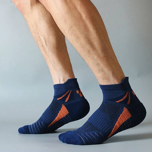 Person wearing navy blue ankle socks with orange stripes and cushioned soles.