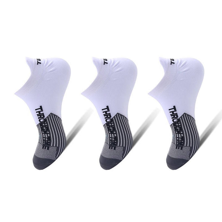 Three white ankle socks with black patterns on the sole, displayed on a white background.